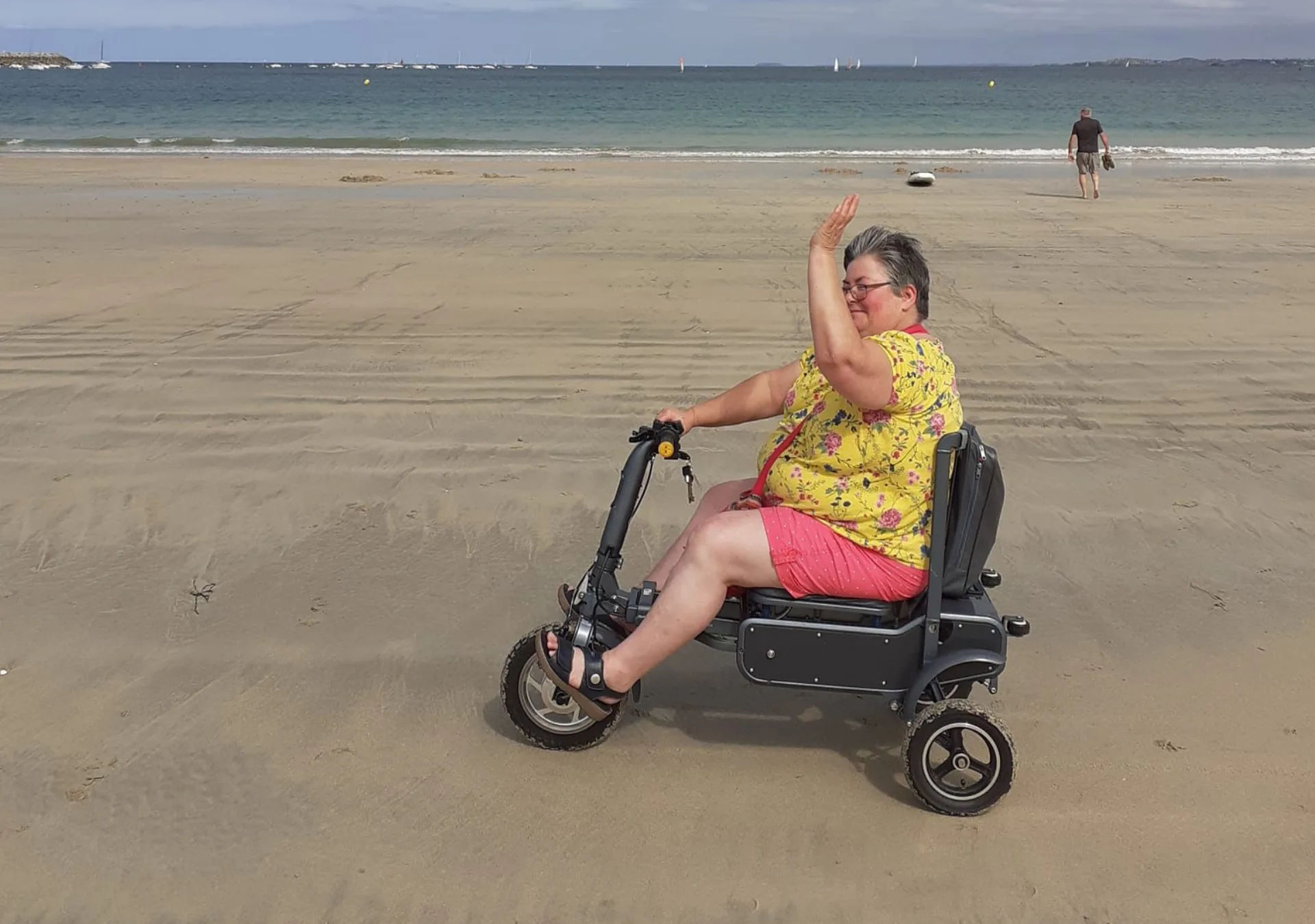 Woman waving from her eFOLDi on a sunny beach