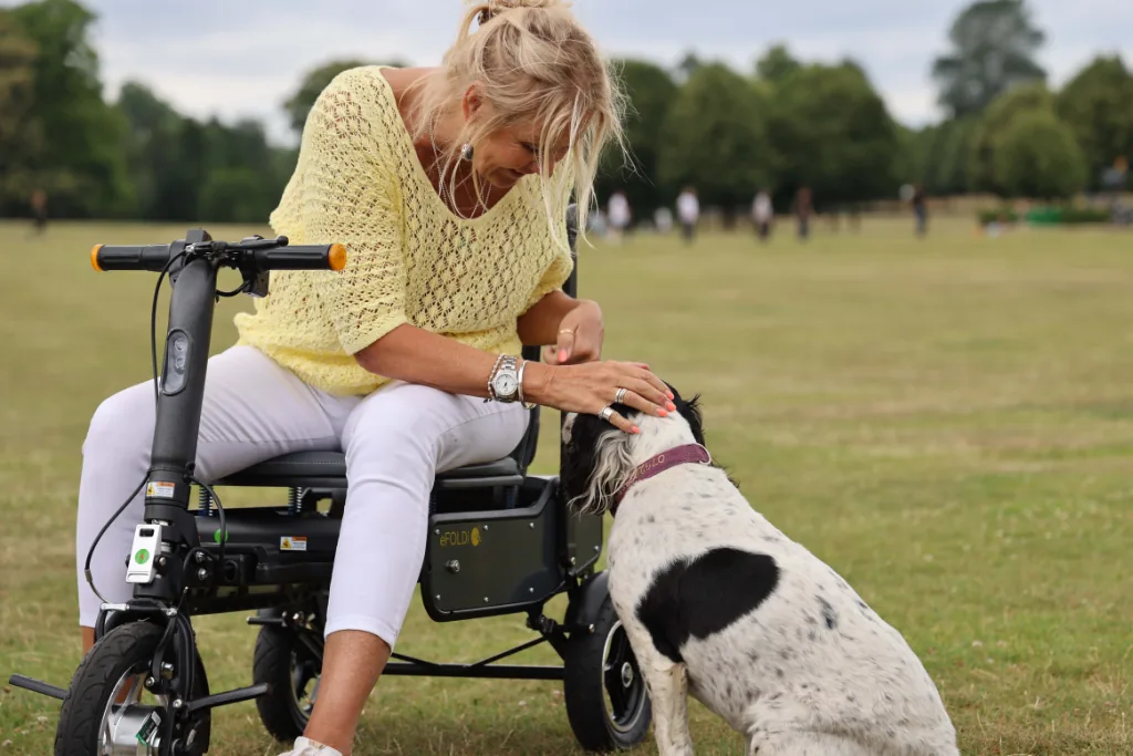 Woman on her eFOLDi greeting a friendly dog in a park